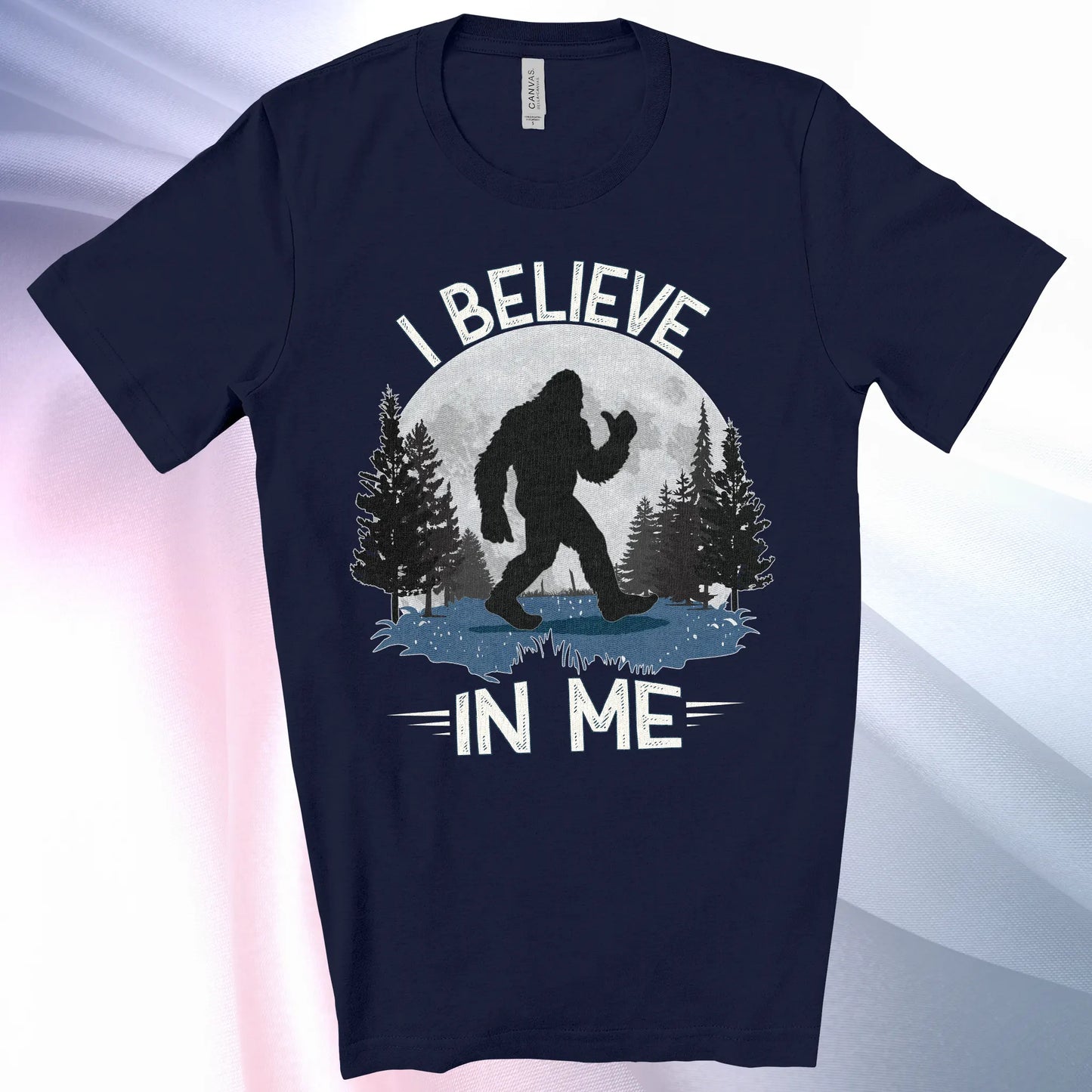 Navy colored Bigfoot Believes T-Shirt with Bigfoot's silhouette in a moonlit forest and I Believe at the top and In Me below