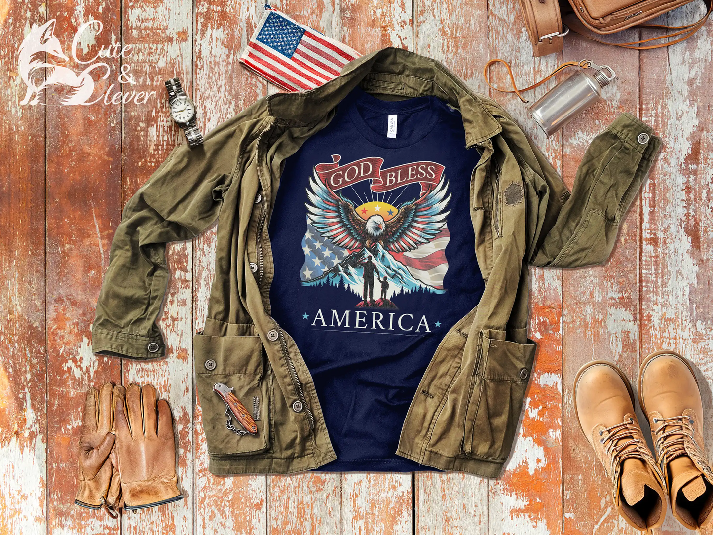 Navy colored Patriotic T-Shirt for Men on rustic wood planks with watch, gloves, rugged boots, belt, jacket, flag patch, hiking bag