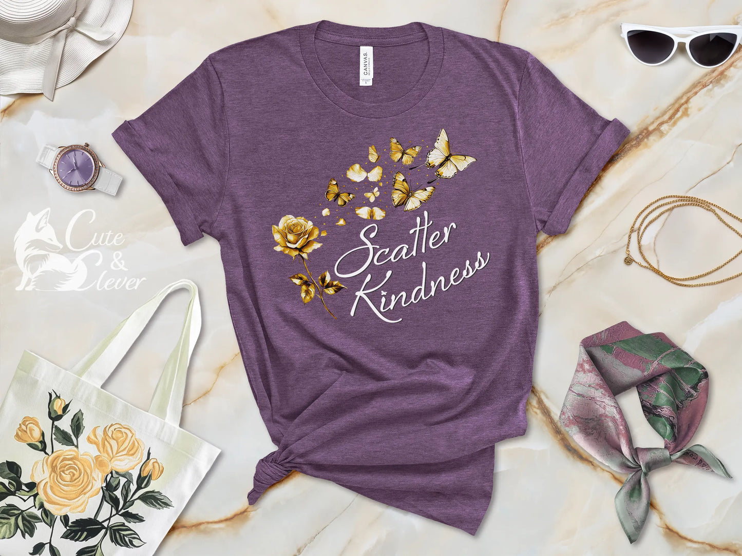 Heather Team Purple colored Scatter Kindness T-Shirt for Women laying on marble surface with scarf, elegant hat, sunglasses, necklace and watch