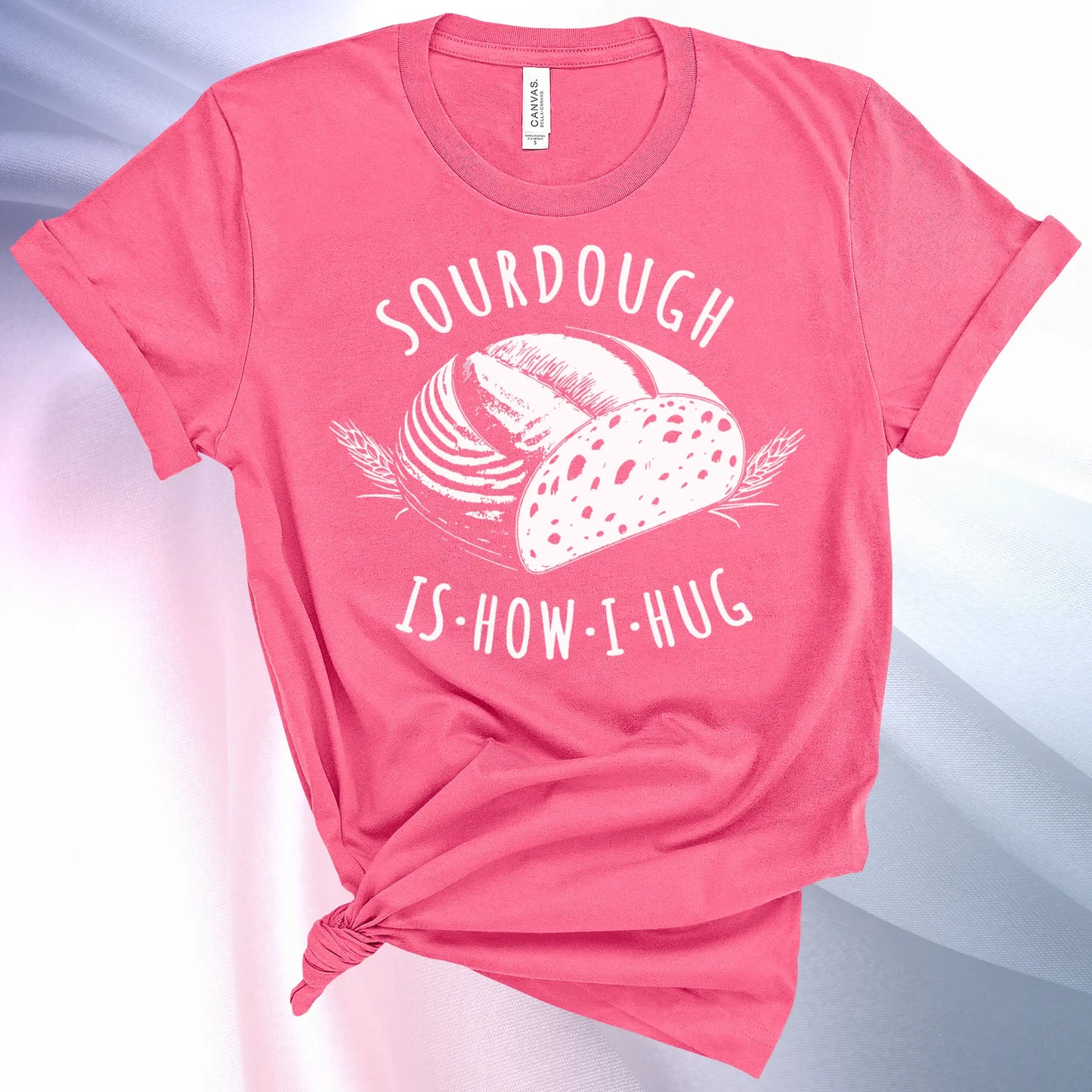 Charity Pink colored Sourdough Hug T-Shirt featuring a loaf of sourdough and "Sourdough" above and "Is How I Hug" below