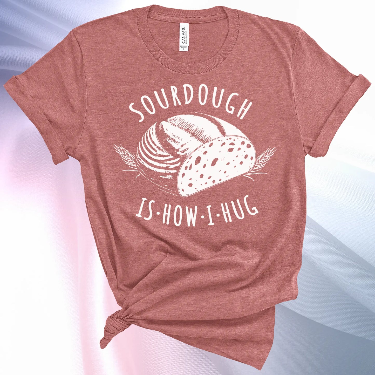 Heather Mauve colored Sourdough Hug T-Shirt featuring a loaf of sourdough and "Sourdough" above and "Is How I Hug" below