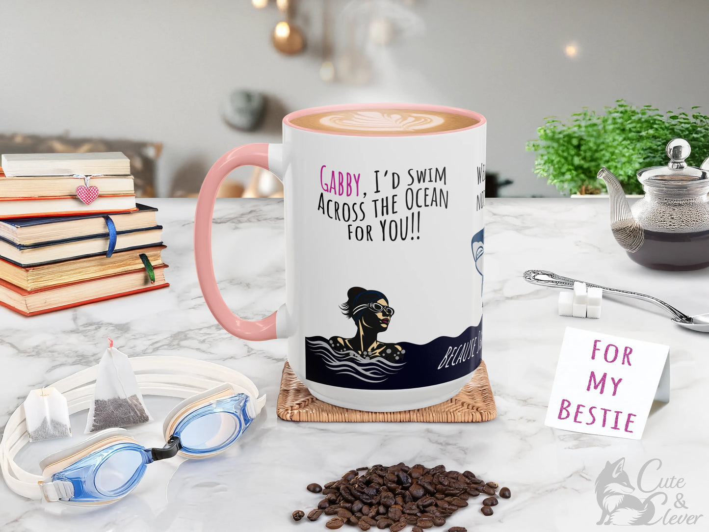 Pink 15Oz Premium Accent Mug gift with Swim the Ocean personalized design on a counter with coffee beans, tea bags, books, sugar