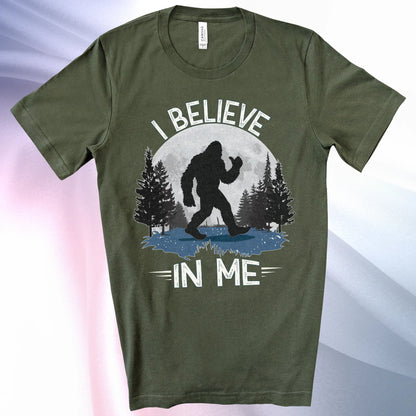 Military Green Bigfoot Believes T-Shirt with Bigfoot's silhouette in a moonlit forest and I Believe at the top and In Me below