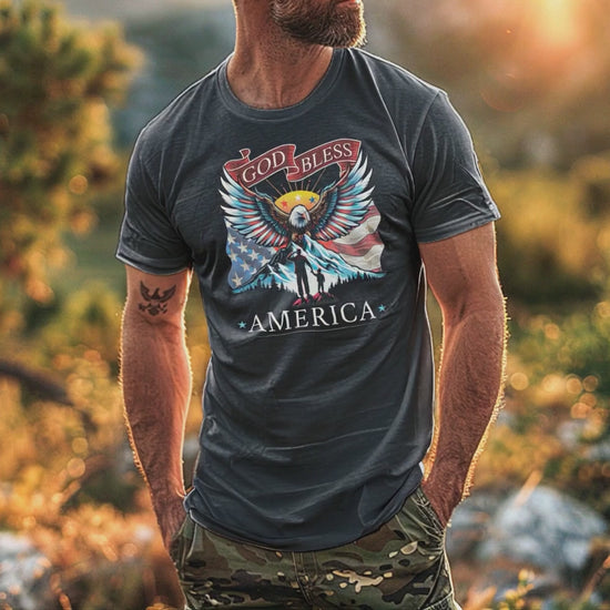 Man wears dark grey heather colored Patriotic T-Shirt for Men in rustic outdoor setting while eagle soars overhead.